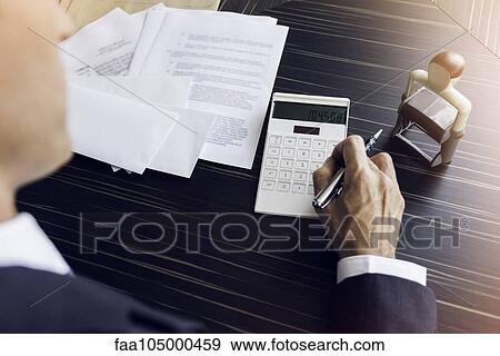 Stock Photo - Businessman doing paperwork. Fotosearch