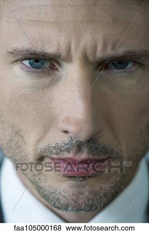 Stock Photo - Businessman glaring with furrowed brow, portrait. Fotosearch