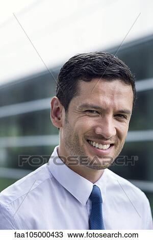 Stock Image - Businessman smiling cheerfully, portrait. Fotosearch
