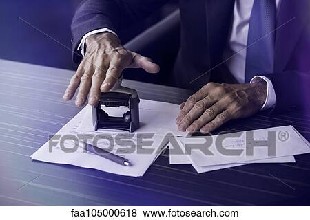 Stock Photo - Businessman stamping document. Fotosearch