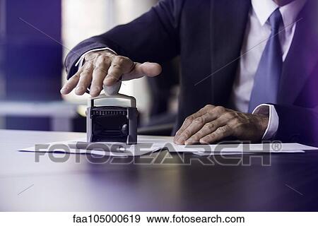 Stock Photo - Businessman stamping document. Fotosearch