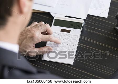 Stock Photograph - Businessman using calculator. Fotosearch