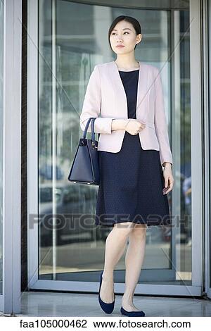 Stock Image - Businesswoman exiting building. Fotosearch