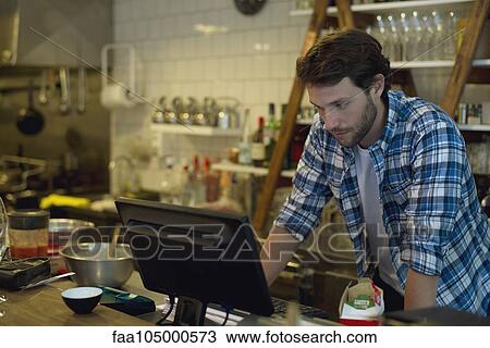 Cafe owner looking at cash register View Large Photo Image Stock Image - Cafe owner looking at cash register. Fotosearch