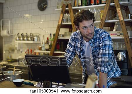 Cafe owner standing behind cash register View Large Photo Image Stock Image - Cafe owner standing behind cash register. Fotosearch