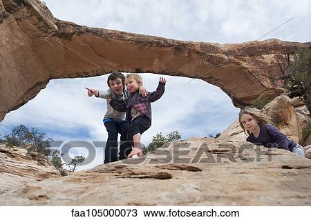 Stock Image - Children exploring near Owachomo Bridge, Natural Bridges National Monument, Utah, USA. Fotosearch