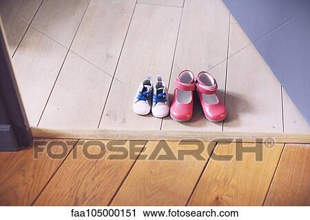 Stock Image - Children's shoes side by side on floor. Fotosearch