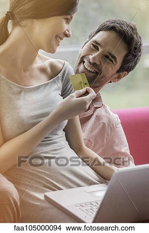 Couple enjoying convenience of online shopping View Large Photo Image Picture - Couple enjoying convenience of online shopping. Fotosearch