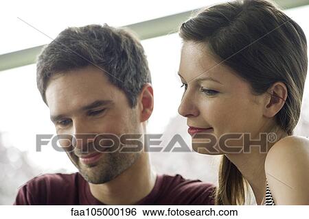 Stock Photograph - Couple relaxing together, both smiling. Fotosearch
