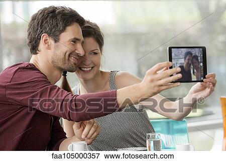 Couple smiling for selfie taken with digital tablet View Large Photo Image Stock Photo - Couple smiling for selfie taken with digital tablet. Fotosearch