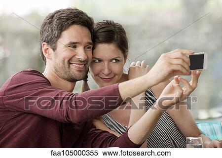 Stock Photography - Couple taking selfie with smartphone. Fotosearch
