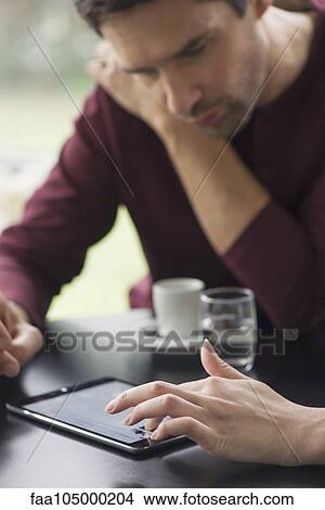 Couple using digital tablet in cafe, cropped View Large Photo Image Picture - Couple using digital tablet in cafe, cropped. Fotosearch
