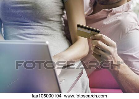 Couple using laptop computer and credit card to shop online, cropped View Large Photo Image Picture - Couple using laptop computer and credit card to shop online, cropped. Fotosearch