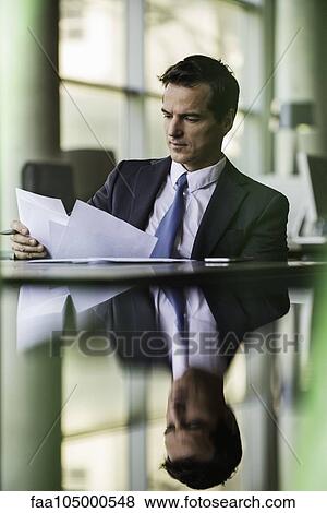 Stock Photo - Executive reviewing paperwork. Fotosearch
