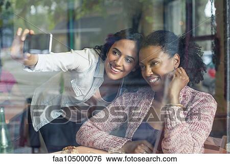 Stock Photograph - Friends taking selfie. Fotosearch