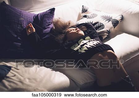 Girl leaning back against sofa, daydreaming View Large Photo Image Stock Photo - Girl leaning back against sofa, daydreaming. Fotosearch