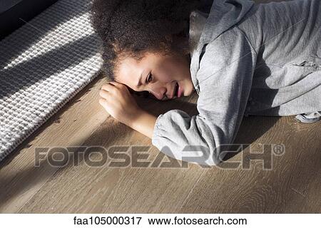 Girl lying on floor crying View Large Photo Image Stock Photo - Girl lying on floor crying. Fotosearch