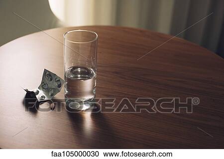 Glass of water and blister pack of medicine on table View Large Photo Image Stock Image - Glass of water and blister pack of medicine on table. Fotosearch