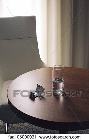 Glass of water and medication on table in hotel room View Large Photo Image Stock Image - Glass of water and medication on table in hotel room. Fotosearch
