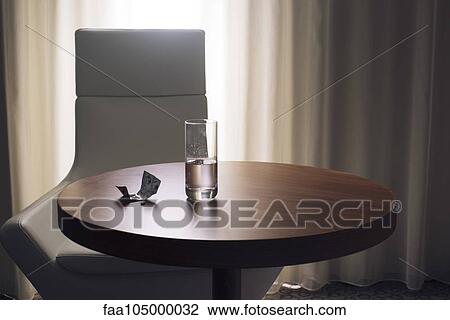 Glass of water and medication on table in hotel room View Large Photo Image Stock Image - Glass of water and medication on table in hotel room. Fotosearch