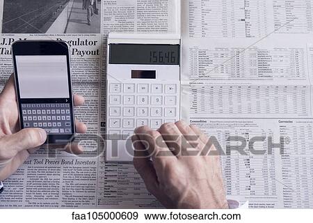 Investor using smartphone and calculator View Large Photo Image Stock Photo - Investor using smartphone and calculator. Fotosearch