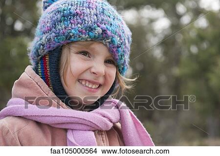 Little girl wearing knit hat and scarf, smiling, portrait View Large Photo Image Picture - Little girl wearing knit hat and scarf, smiling, portrait. Fotosearch
