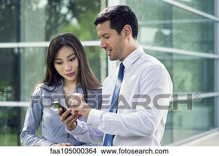 Picture - Man and woman looking at smartphone together. Fotosearch
