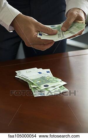 Man counting stack of cash, cropped View Large Photo Image Picture - Man counting stack of cash, cropped. Fotosearch