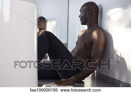 Man sitting on floor with book, looking at himself in mirror View Large Photo Image Stock Photography - Man sitting on floor with book, looking at himself in mirror. Fotosearch