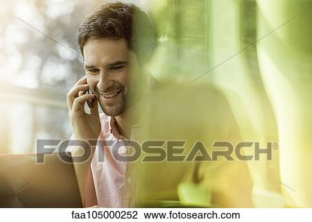 Man smiling while chatting on cell phone View Large Photo Image Stock Image - Man smiling while chatting on cell phone. Fotosearch