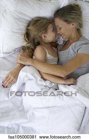 Mother and daughter in bed embracing View Large Photo Image Stock Image - Mother and daughter in bed embracing. Fotosearch