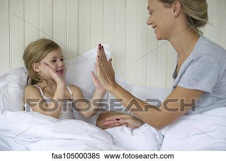 Stock Photography - Mother and daughter playing clapping game. Fotosearch