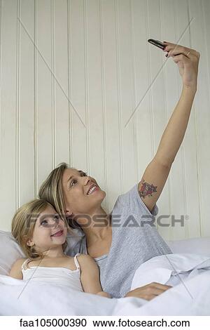 Stock Image - Mother and daughter posing for selfie. Fotosearch