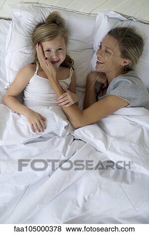 Mother and daugther lying in bed together View Large Photo Image Stock Photo - Mother and daugther lying in bed together. Fotosearch