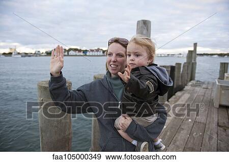 Mother and young son waving on pier View Large Photo Image Stock Photo - Mother and young son waving on pier. Fotosearch