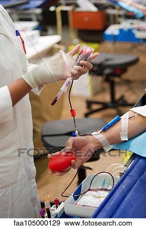 Stock Photo - Person donating blood, cropped. Fotosearch