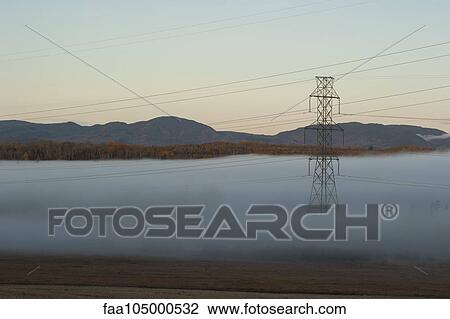 Stock Image - Power lines running through foggy rural landscape. Fotosearch