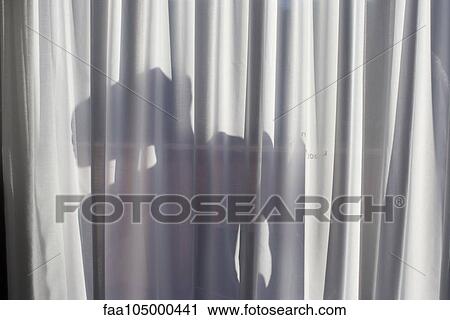 Stock Image - Shadow of a person on window curtain. Fotosearch