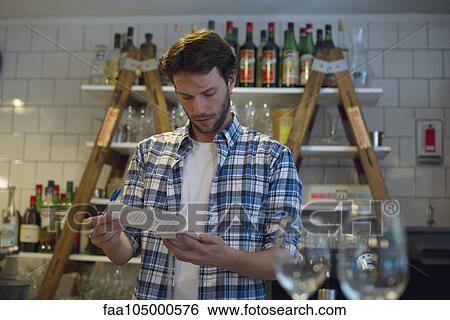 Shopkeeper reviewing paperwork View Large Photo Image Stock Photograph - Shopkeeper reviewing paperwork. Fotosearch