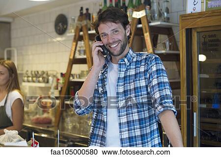 Shopkeeper taking phone call View Large Photo Image Stock Image - Shopkeeper taking phone call. Fotosearch