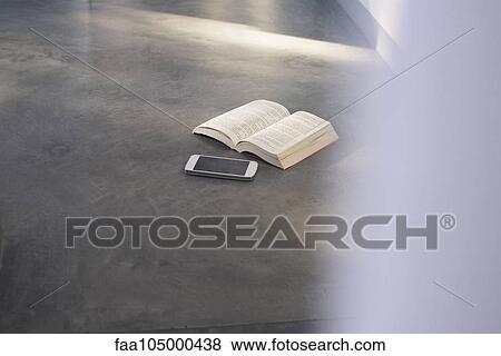 Smartphone and open book lying on floor View Large Photo Image Stock Photo - Smartphone and open book lying on floor. Fotosearch