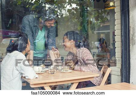 Waiter talking to customers in coffee shop View Large Photo Image Picture - Waiter talking to customers in coffee shop. Fotosearch