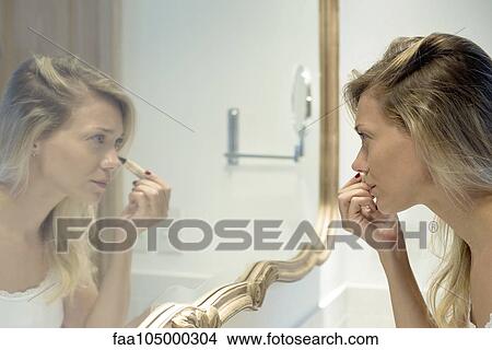 Woman applying cosmetics View Large Photo Image Picture - Woman applying cosmetics. Fotosearch