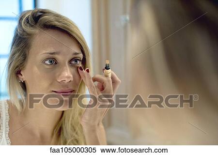 Stock Photography - Woman applying cosmetics. Fotosearch
