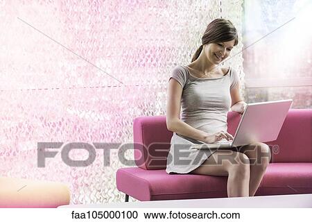 Stock Image - Woman at home using laptop computer. Fotosearch