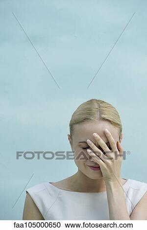 Stock Image - Woman covering face with hand. Fotosearch