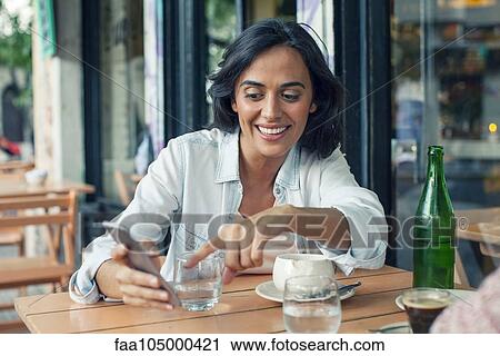 Woman looking at smartphone View Large Photo Image Stock Image - Woman looking at smartphone. Fotosearch