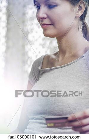Stock Image - Woman making purchase with credit card. Fotosearch