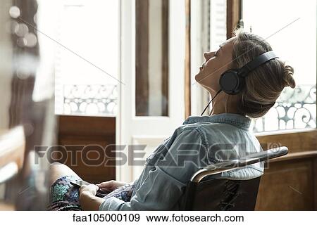 Woman relaxing while listening to music View Large Photo Image Stock Photo - Woman relaxing while listening to music. Fotosearch