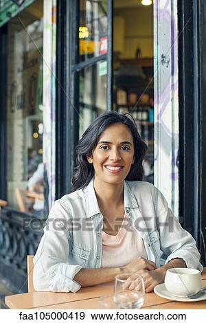 Stock Photo - Woman sitting at sidewalk cafe. Fotosearch